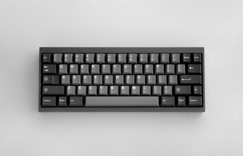 Compact Keyboard - a black keyboard sitting on top of a white table