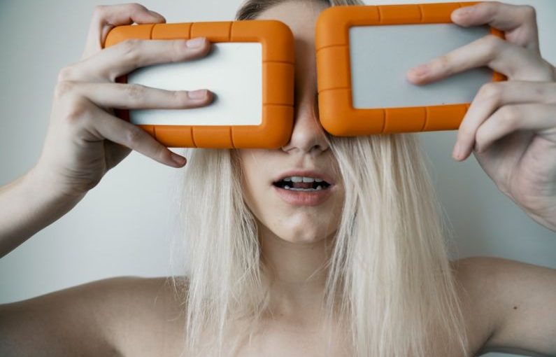 External Storage - woman holding two white-and-orange plastic cases