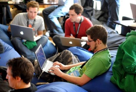 Networking Peripherals - man sitting on blue bean bag usinglaptop