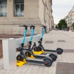 Docking Station - a row of scooters sitting on the side of a road