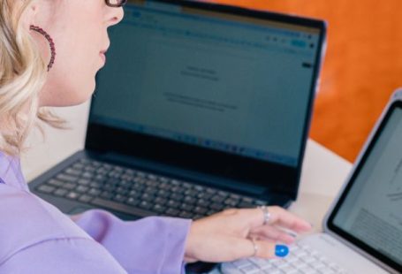 Professional Setup - A woman in a purple shirt is using a laptop