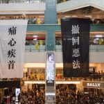 Media Center - Shopping centre with hanging protestant banners crowded with people on meeting