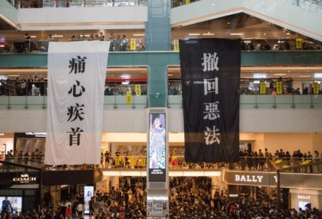 Media Center - Shopping centre with hanging protestant banners crowded with people on meeting