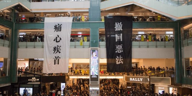 Media Center - Shopping centre with hanging protestant banners crowded with people on meeting