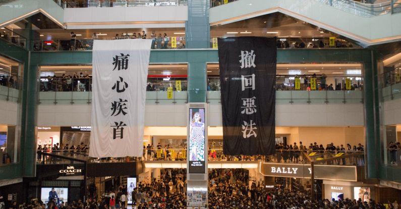 Media Center - Shopping centre with hanging protestant banners crowded with people on meeting