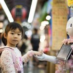 Robot - photo of girl laying left hand on white digital robot