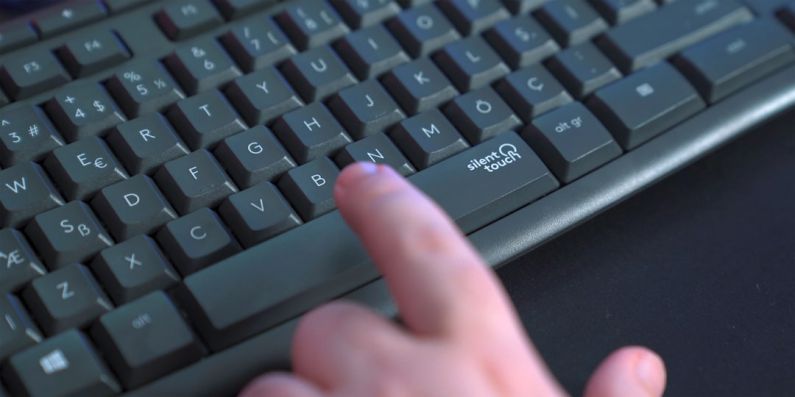 Silent PC - a person pressing a button on a keyboard