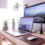 Network Setup - MacBook Pro on table beside white iMac and Magic Mouse