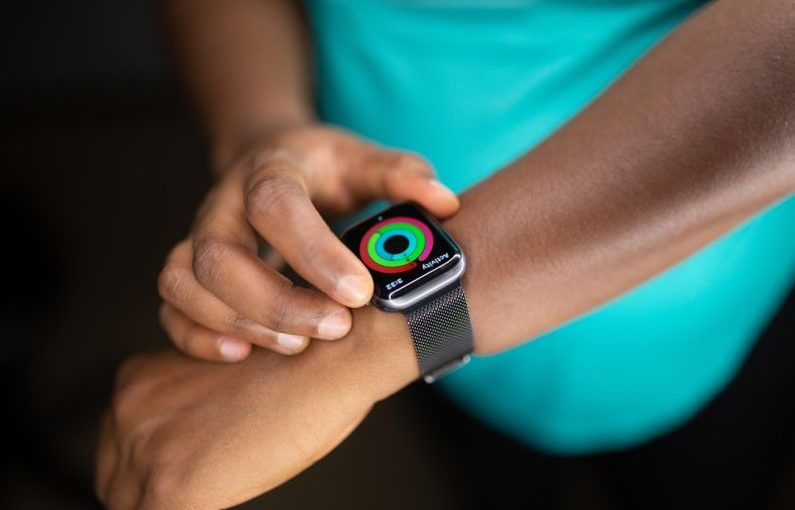 Wearable Technology - person wearing silver aluminum case apple watch with white sport band